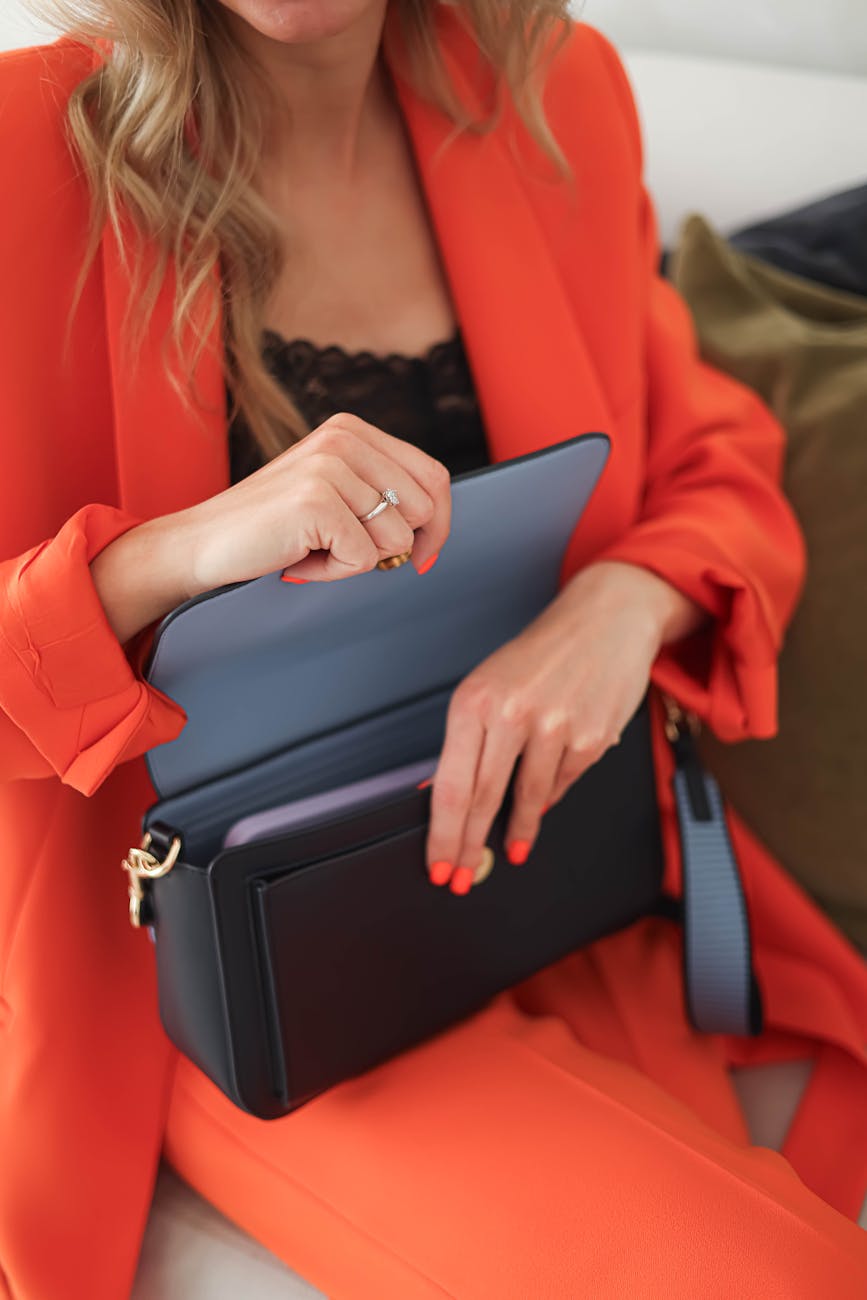 woman in red suit opening a black leather purse